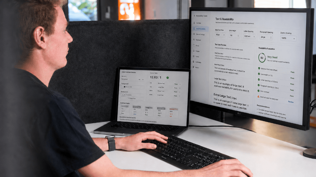 Nahaufnahme eines Schreibtisch-Setups, das auf Laptop und großem Bildschirm Lesbarkeitswerte und UI-Prüfungen anzeigt.