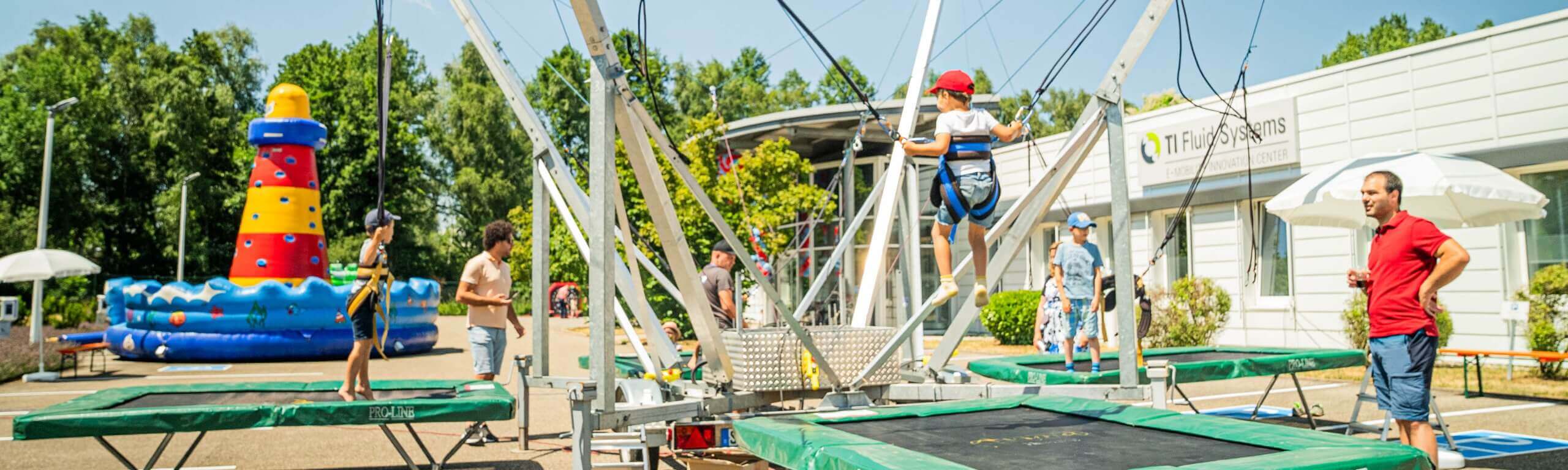 Kind springt an einem Bungee-Trampolin auf dem Crypton Event unter Aufsicht.
