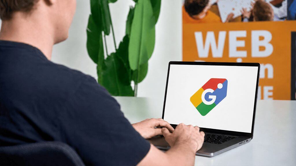 Agent arbeitet am Laptop mit Google Shopping-Symbol, konzipiert Kampagnen für eine Google Shopping Agentur.