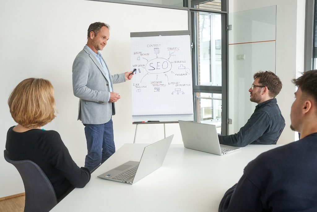 Sascha Krummeich erklärt einer Gruppe an einem Flipchart die Kernelemente einer SEO-Strategie.