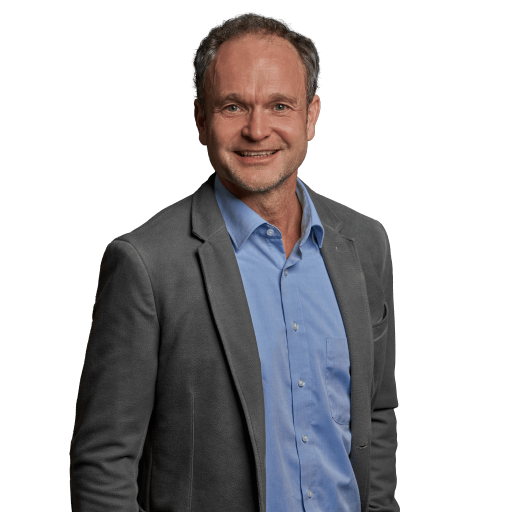 Locker stehender Berater im grauen Sakko und blauem Hemd, wirkt offen und vertrauenswürdig.